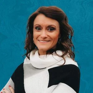 Amanda Pennington Smiling In Front Of Blue Background